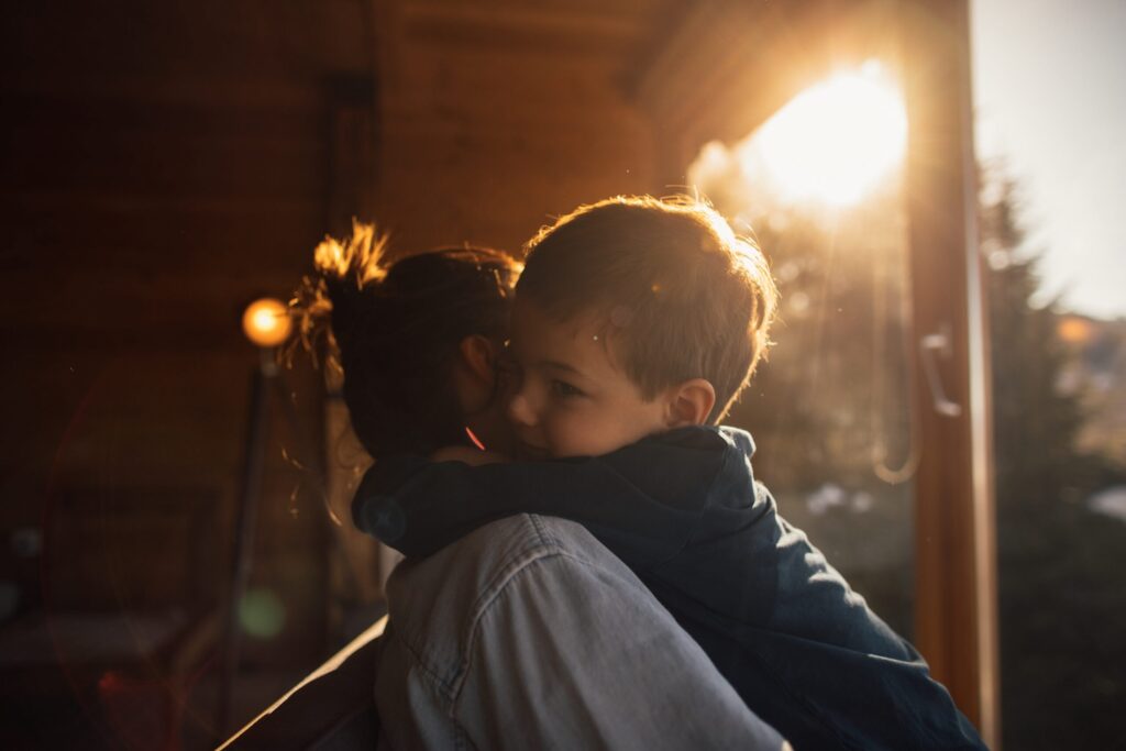 Image of a boy sitting on his moms back