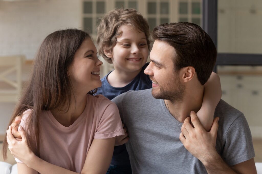 Image of parents holding their son over their shoulder