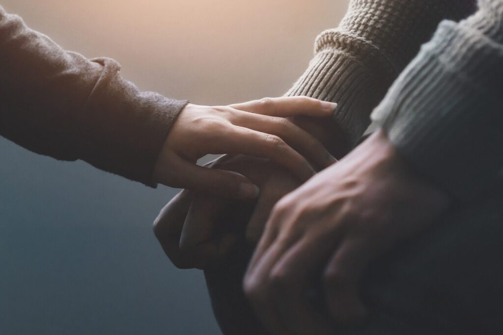 Image of people holding hands sadly