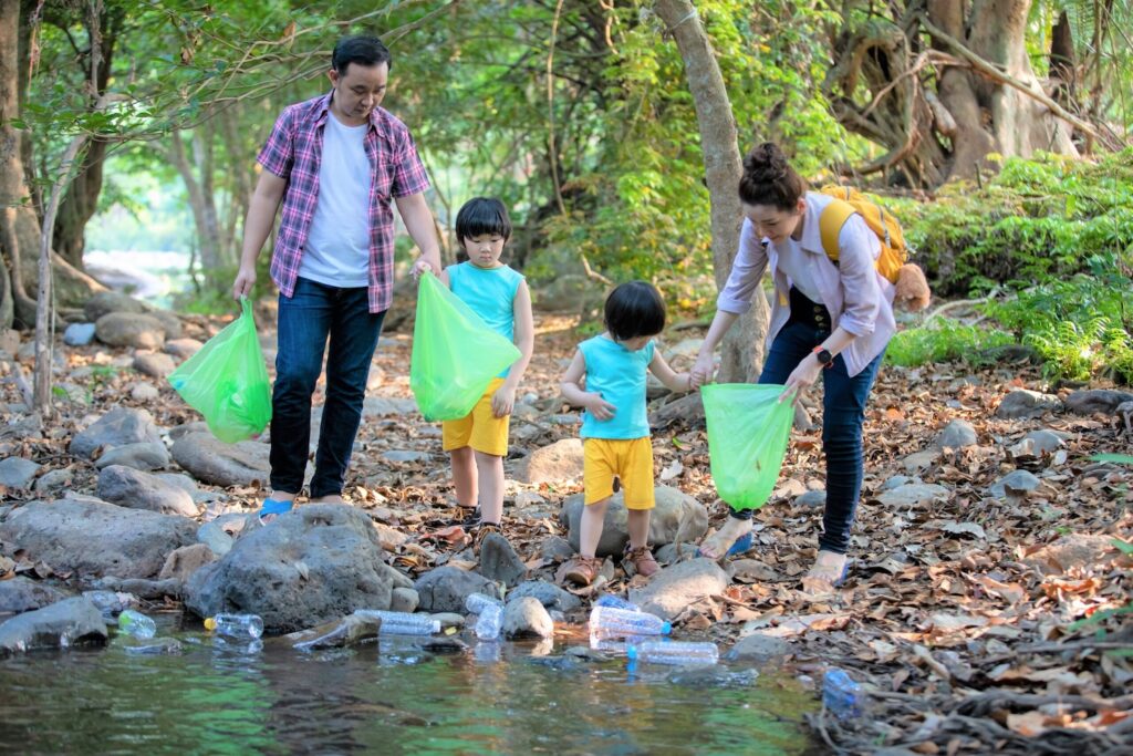 Image of Asian Family volunteer picking up a plastic bottle on river