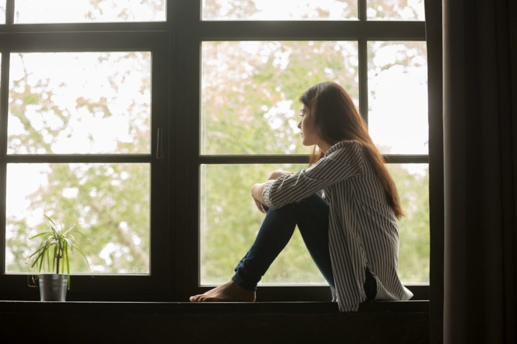 Image of a girl staring sadly out the window