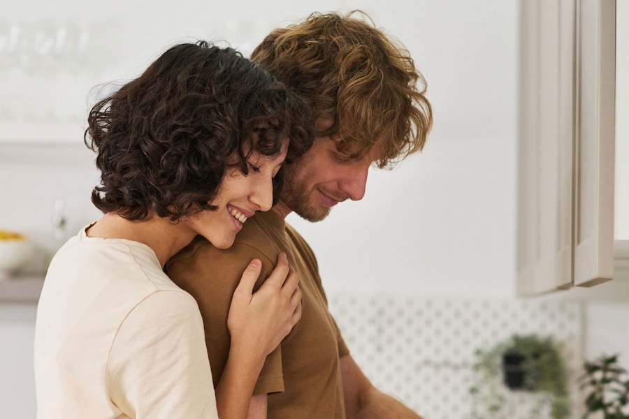 Image of a woman hugging a man in the kitchen