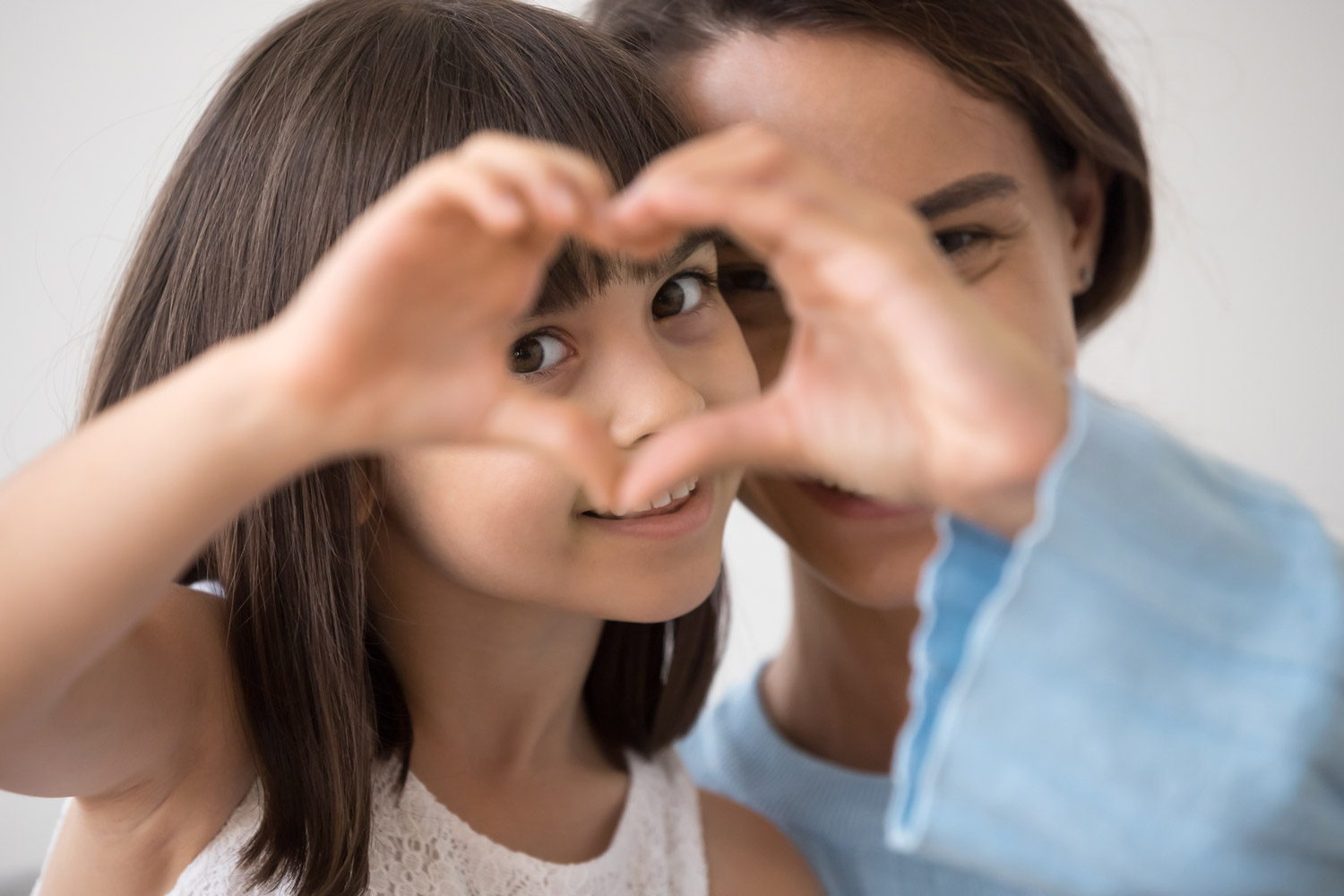 little happy girl and mother join hands forming heart shape as concept of giving love