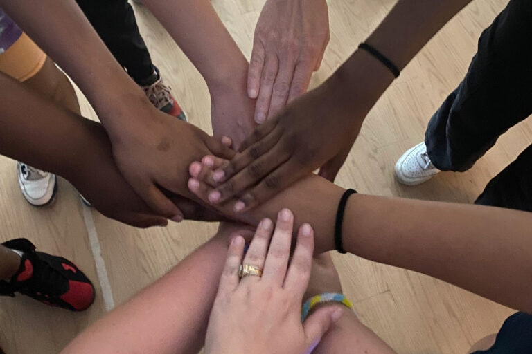 Image of people placed their hands together in a circle