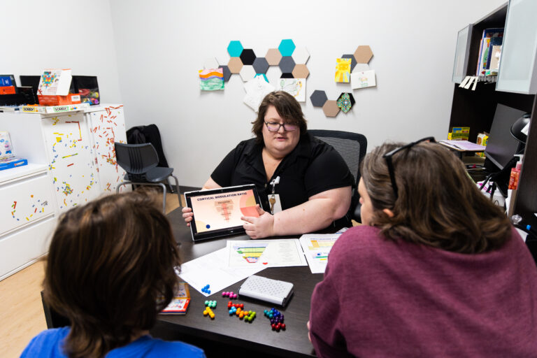 A lady giving talking about assessments to caregivers.