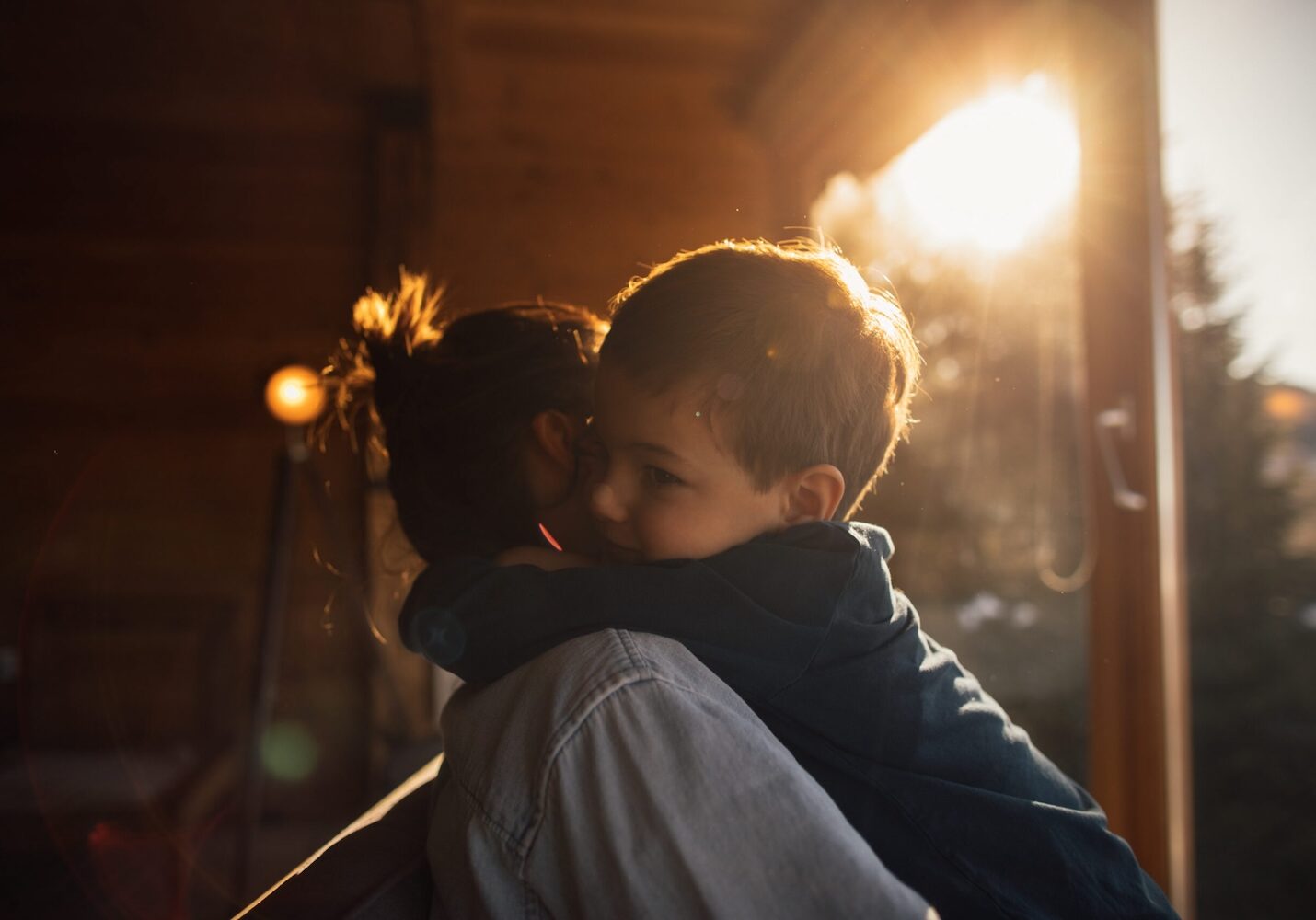 Image of a boy sitting on his moms back