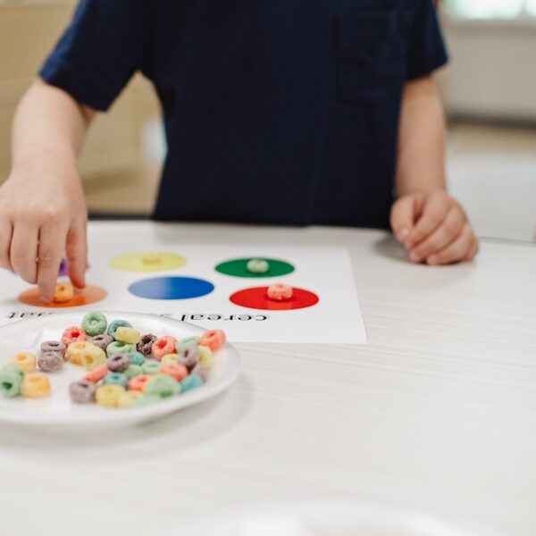 Image of a young boy putting fruit loops into colored circles