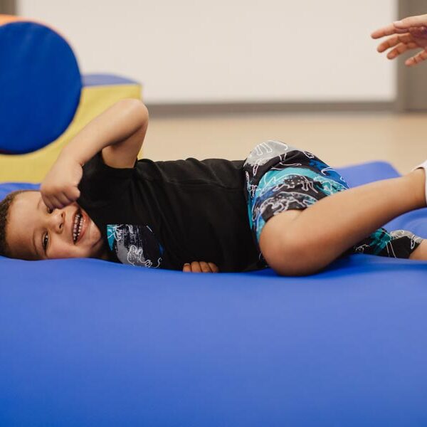 Image of a young boy laying on a bean bag and smiling