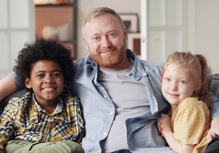 Image of a man hugging two kids