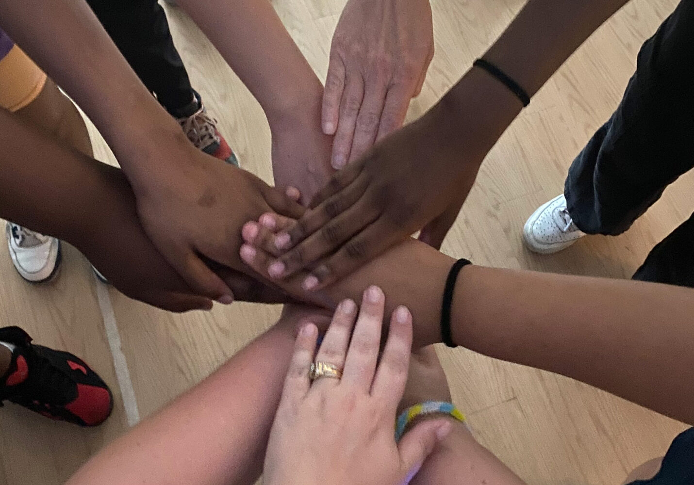 Image of people placed their hands together in a circle