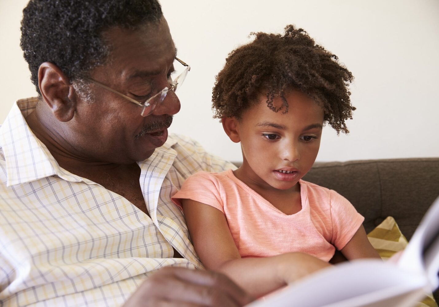 Image of a girl reading a book with her grandfather