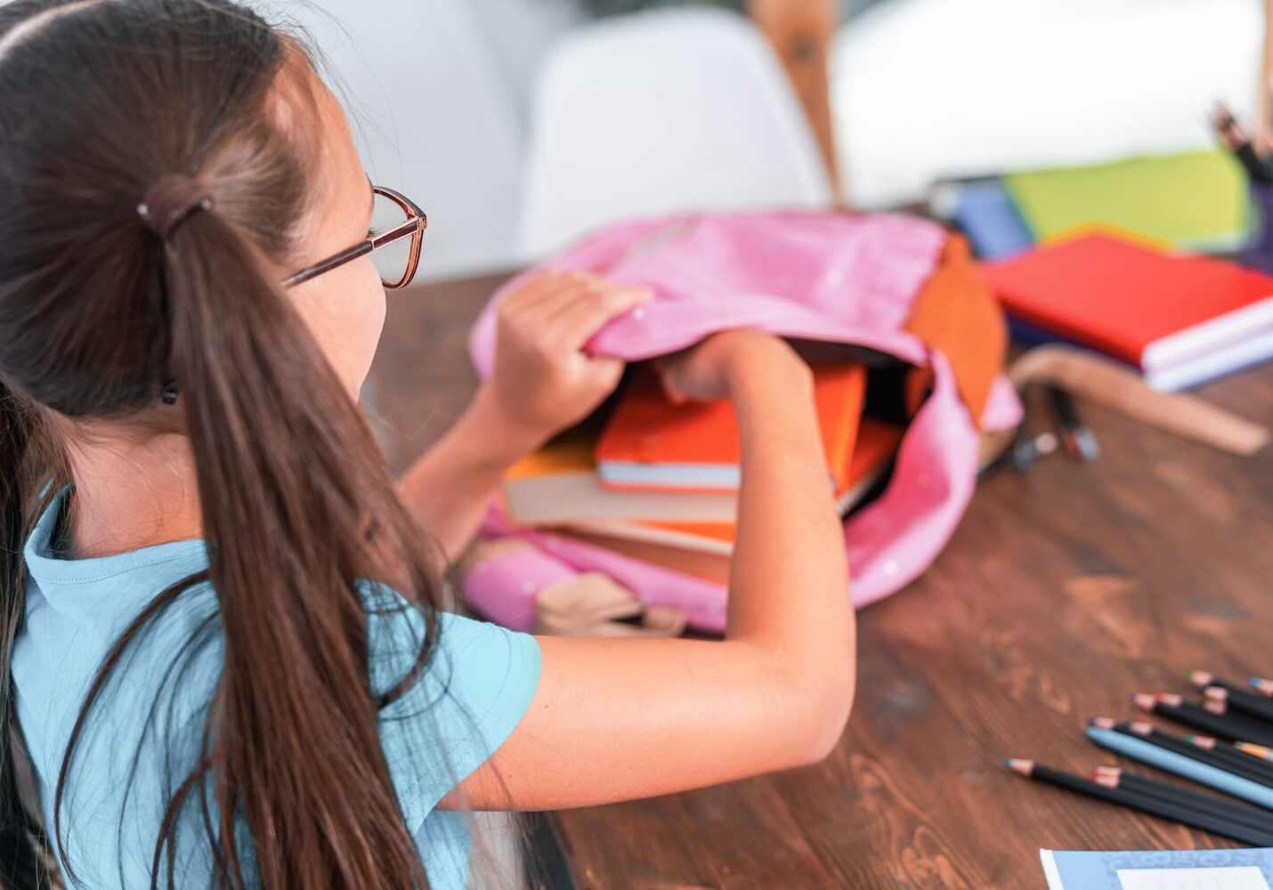 Image of a girl unloading school supplies from her backpack