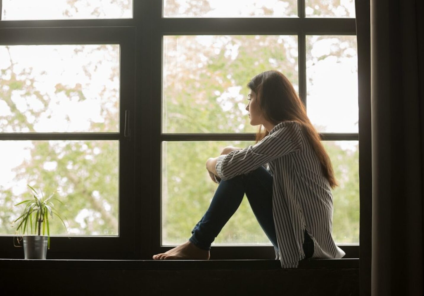 Image of a girl staring sadly out the window